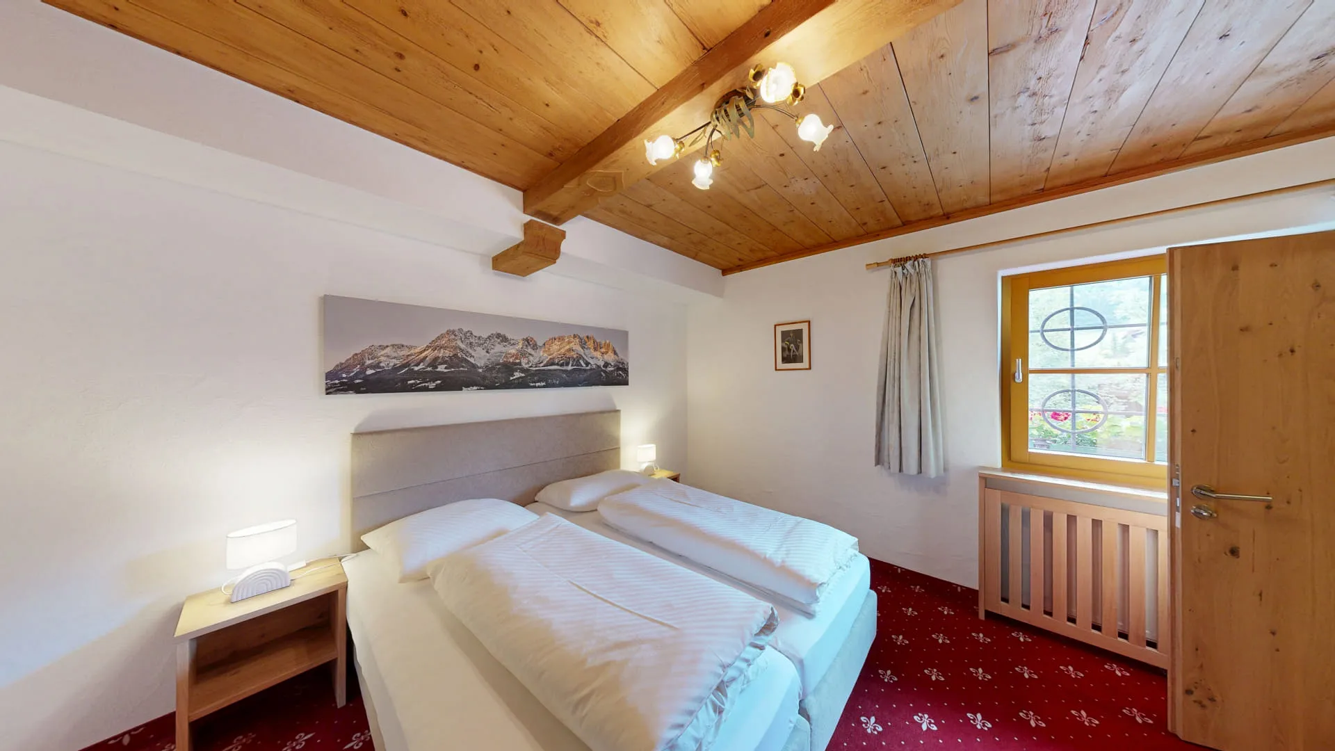 Hotelzimmer mit zwei Betten, Holzdecke und Fenster mit Aussicht